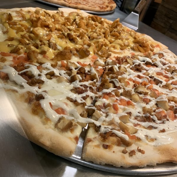 Aljon's Grill Pizzeria's pizza with two distinct halves, one with yellow sauce, the other with white.